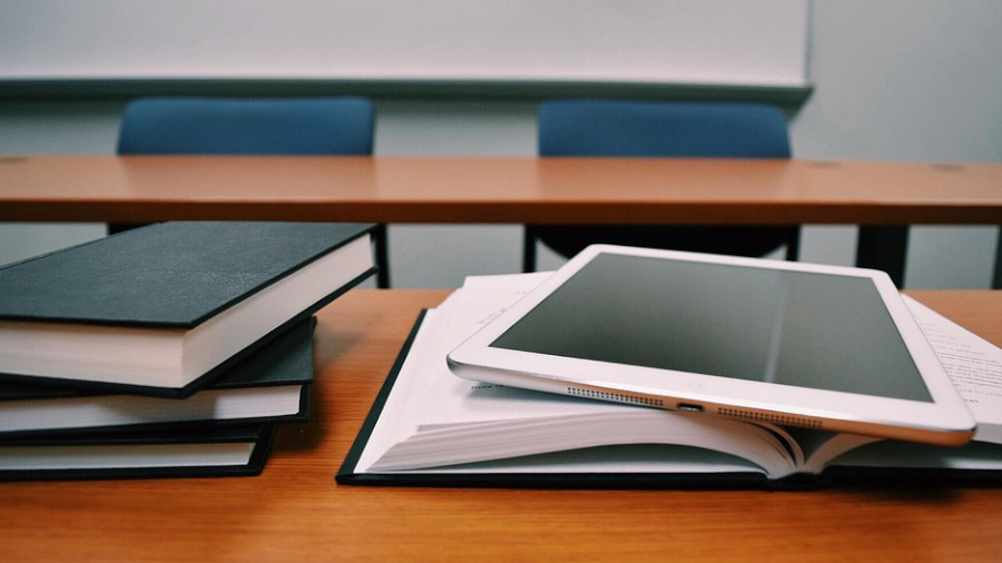 Bücher und Tablet im Klassenzimmer.