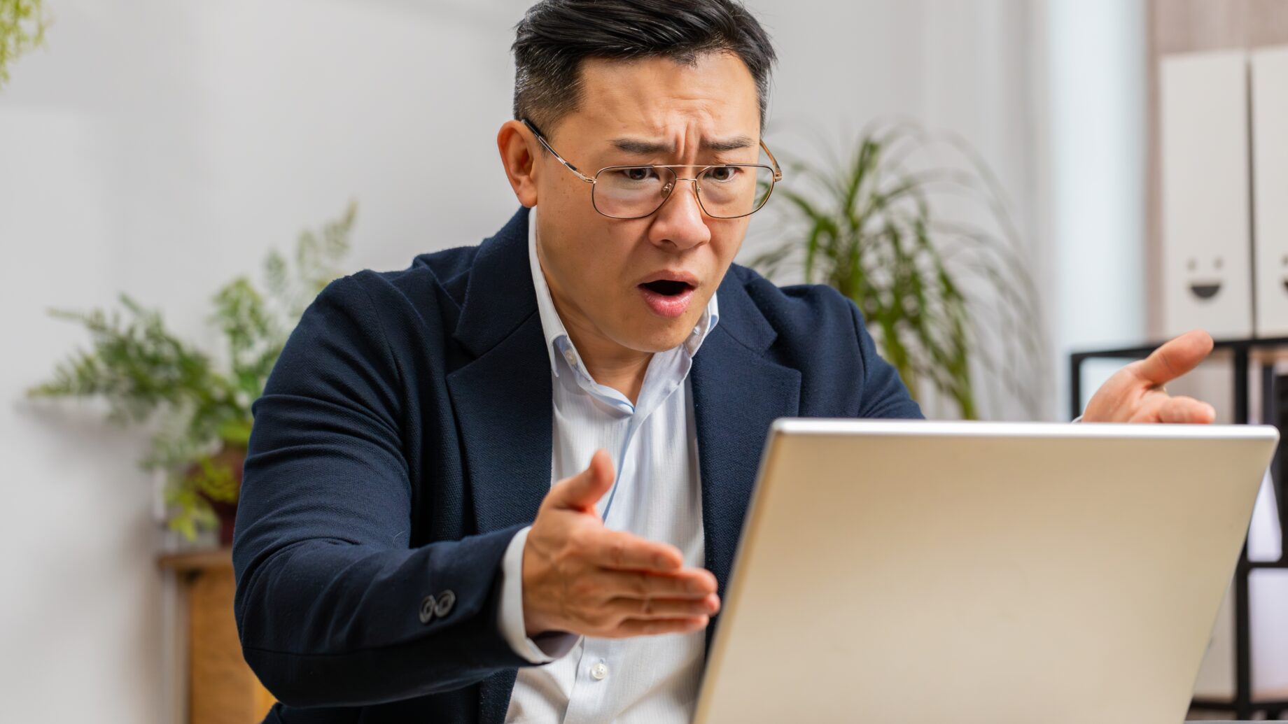 Wütender chinesischer Mann vor dem Notebook
