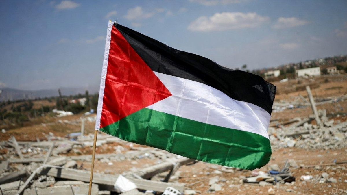 Palästina-Flagge vor verwüstetem Land.