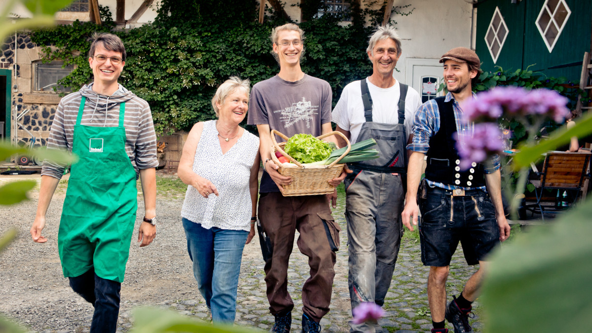 Das Team vom Biohof Groß - vierzig Jahre nach Tschernobyl und der Umstellung auf Bio. In der Mitte Christel, Malte und Dietmar Groß. Neben ihnen Maltes Freunde Florian Werle und in Handwerkerkluft Niklas Welschof. Sie haben mit Malte zusammen den Hof übernommen. | Foto: Sonja Herpich / Bioland