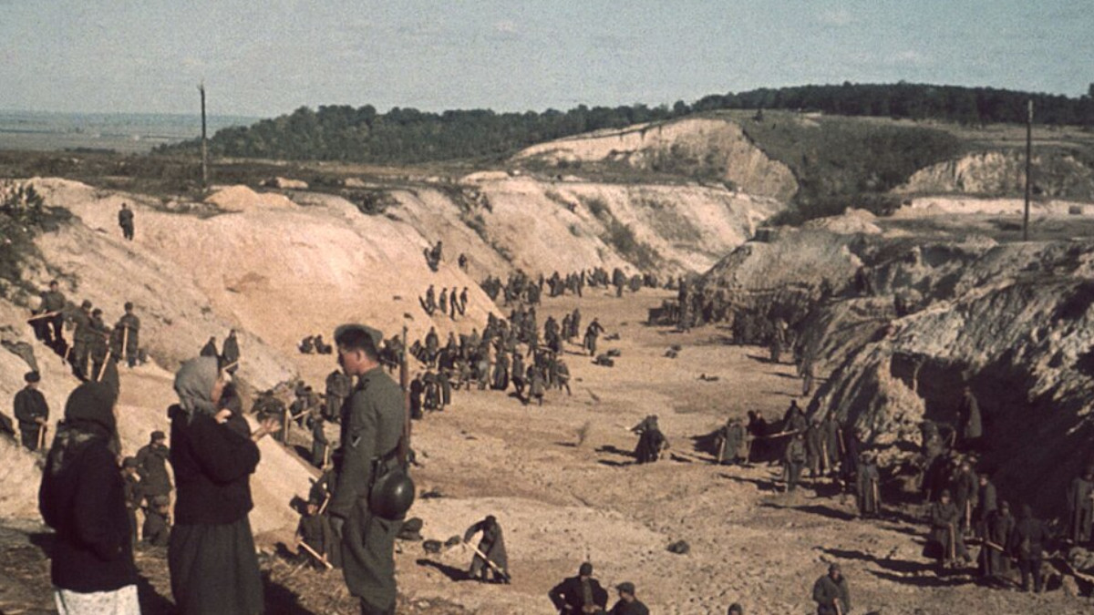 Sowjetische Kriegsgefangene schaufeln nach dem Massaker von Babyn Jar ein Massengrab zu.