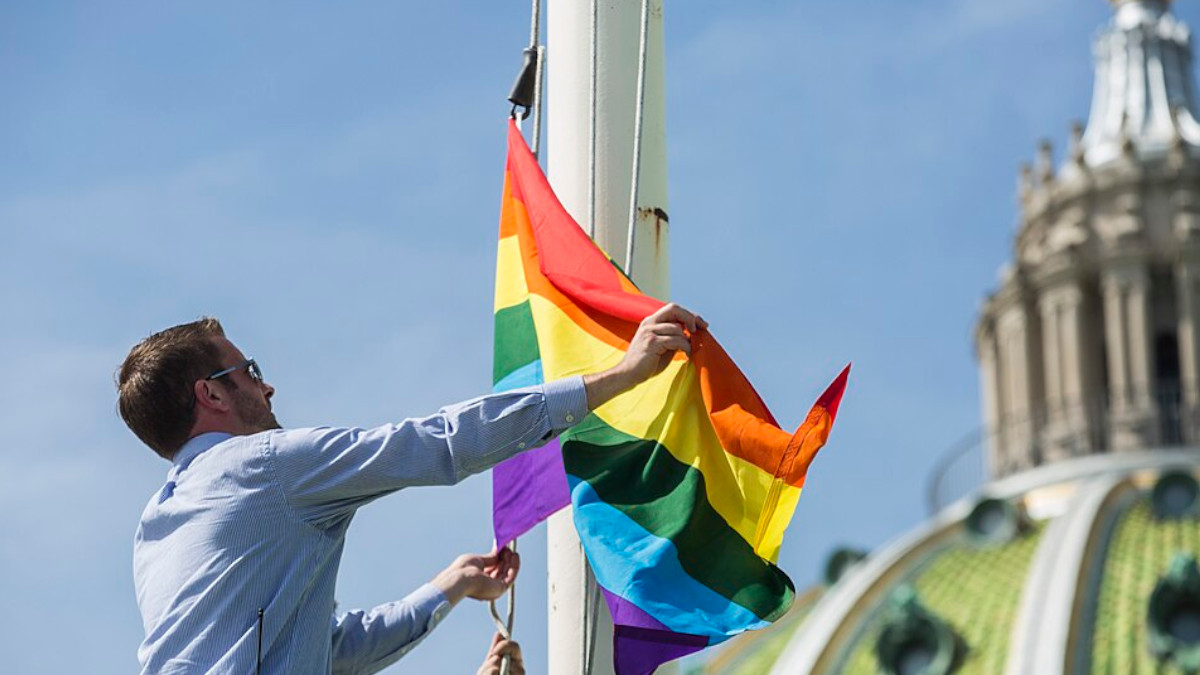 Mann hisst Regenbogenflagge